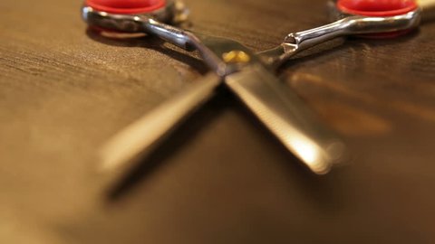 Thinning scissors on wooden table in barbershop, focus moves on subject