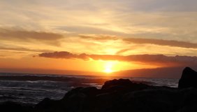 Ocean sunset with cloud, crashing wave and yellow, orange and red sky. HD Video