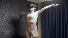 Beautiful young woman wearing VR Headset at bedroom. Looking around and represents what flies. Watch VR video, play VR game. Virtual reality concept.