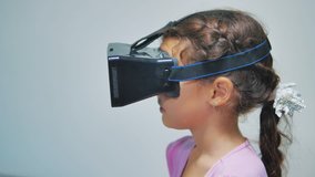 Happy young little girl using 3d goggles a virtual reality headset. Surprised woman with VR device. Happy smiling girl with virtual reality glasses on lifestyle head. entertainment virtual reality