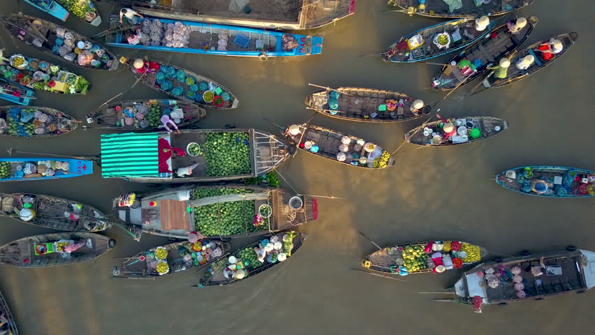 DRONE, TOP DOWN: Flying above local people doing business on the colorful floating market set on the calm murky river in the scenic Vietnamese countryside. People doing business on their wooden boats. Royalty-Free Stock Footage #1019108749
