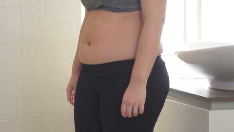 Model tucking in her tummy with body shaper leggings