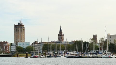 View of the city of Dunkirk, in the north of France. In the foreground, there is the Dunkerque marina. In the background, the famous towers of the city, included the city belfry of the city hall.