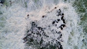 Rocky coastline with crashing waves, aerial drone view