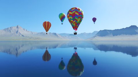 Colorful hot air balloons flying over the lake surrounded by mountains. Four large multi-colored balloons slowly rising against blue sky. Reflection on the clear water. Travel, adventure, festival.
