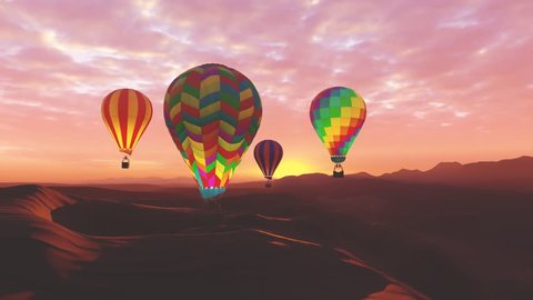 Colorful hot air balloons flying over mountains and desert landscape during sunset. Four large multi-colored balloons slowly rising against a beautiful cloudy pink sky. Travel, adventure, festival.
