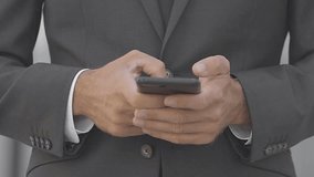 Cropped view of businessman chatting on street. Front view of manager in suit using smartphone. Communication concept