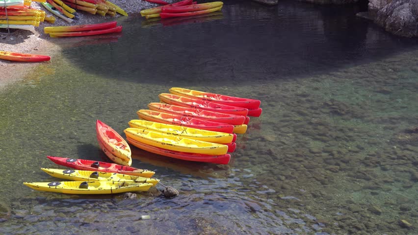 Yellow and red canoes by the sea on a clear day
