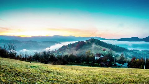Majestic sunset time lapse of a beautiful rural mountain area with fog and village in the distance. Mountain landscape, Zaovine, Serbia.