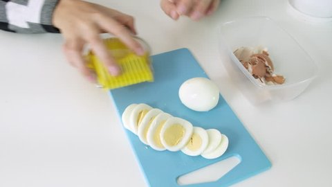 Cutting eggs of egg slicer on board close-up