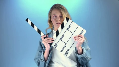 Pretty blonde actress posing for audition with movie clapper board, casting