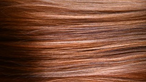 Hair. Beautiful healthy long smooth flowing brown coloring hair close-up texture. Dyed straight hair background, coloring, extensions, cure, treatment concept. Haircare. Slow motion 4K UHD video