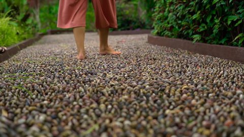 slowmotion shot of a young woman walking on a reflexological path in a tropical park