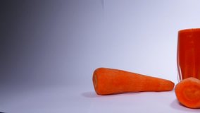 Carrot juice in a tube with a tube. Juices, cocktails, vitamins. Video in the studio for advertising juice.