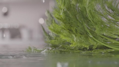 Falling of dill into the wet table. Slow motion 240 fps
