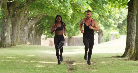 4K Personal trainer running in the park with fit athletic female client
