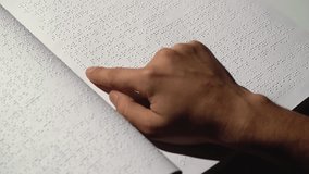 Man fingers read Braille writing. Close up