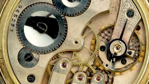 Gears in the mechanism of a vintage pocket watchl. Close up. Time lapse . Back background