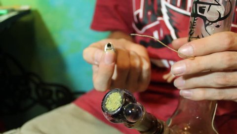 American Stoner lighting up a medical marijuana keef bong with hemp wick