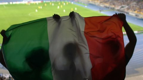 Soccer fans with Italian flag jumping in stands, cheering for favorite team