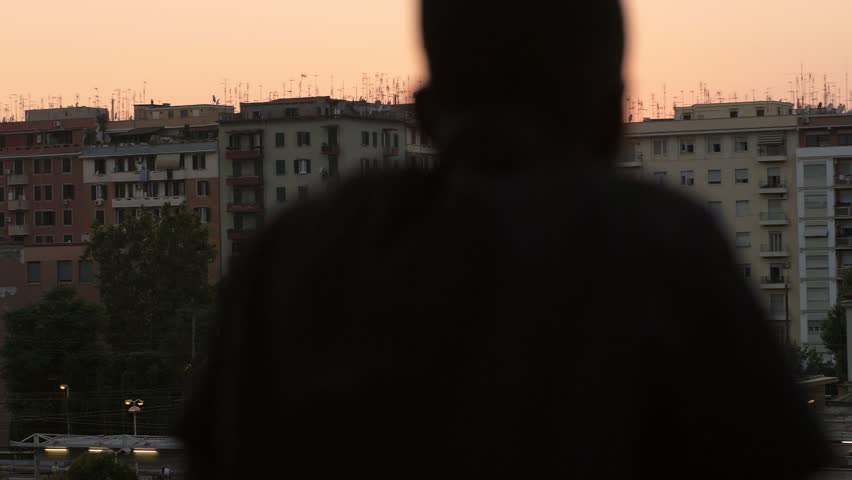 man silohuette contemplating the city at sunset-city, urbanization, modernity