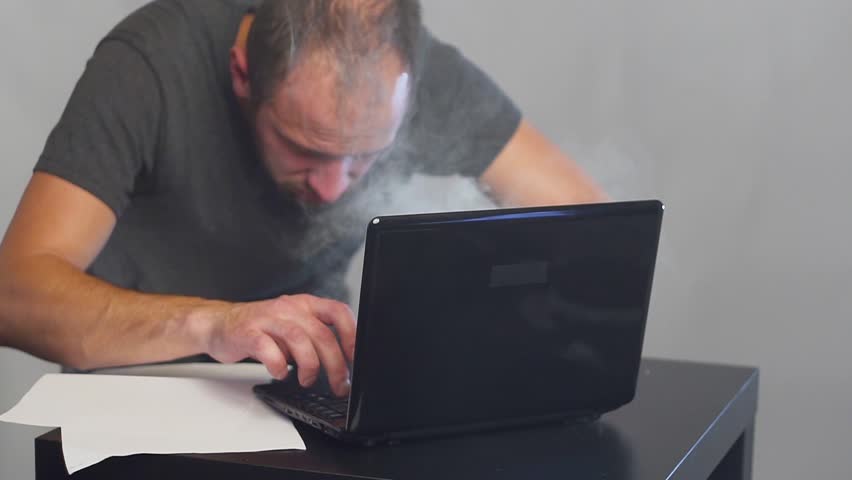 Crazy fanatical businessman working on a burning computer. Accountant report. Cryptocurrencies. Royalty-Free Stock Footage #1019226034