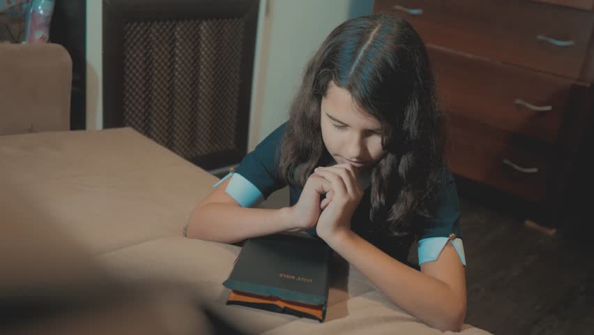 little girl holy bible prays with bible lifestyle in her hands. the catholicism sacred holy bible . children and religion upbringing faith symbol . Little girl with praying . Peace , hope, dreams
