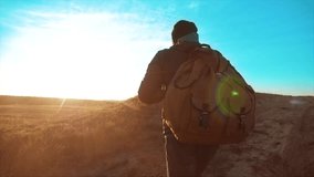 Silhouette hiker man of backpacker. steadicam motion video sunlight sunset person side view walking toward successful. lonely man with sunset background.Travel and success concept the adventure