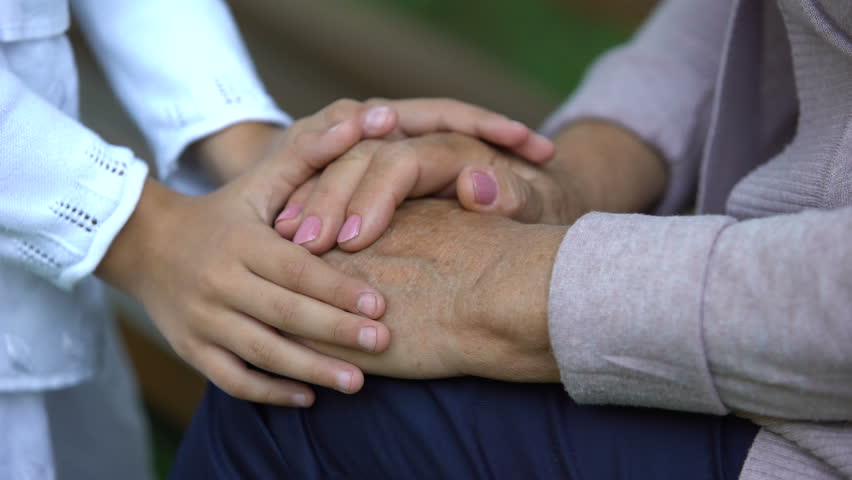 Little girl gently stroking hands of her elderly grandmother, love and care | Shutterstock HD Video #1019232043