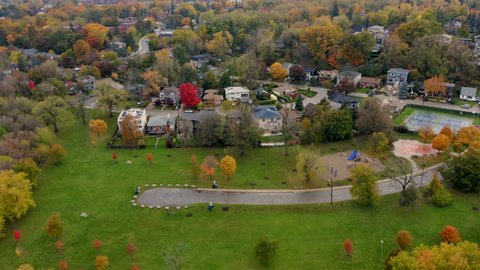 Aerial shot tracking away from park and houses off the edge of Scarborough Bluffs during peak fall colors. 