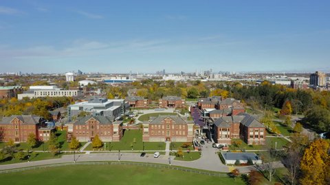 Aerial rising tracking shot of college campus during sunny autumn morning. 