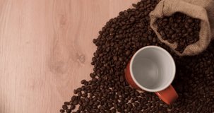 Coffee pouring from coffee pot on wood background with scattered coffee beans top view composition 4K video