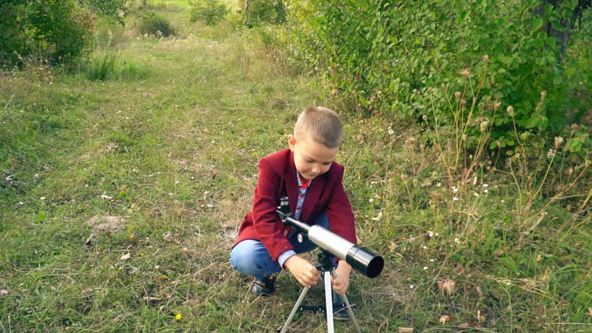 boy with a telescope in nature