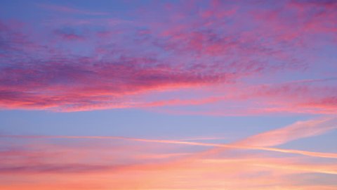 Amazing time-lapse with last moments of evening blue sky with pink and red  clouds. Quickened motion of heaven vapor on limitless space. Abstract natural background with tranquil effect.