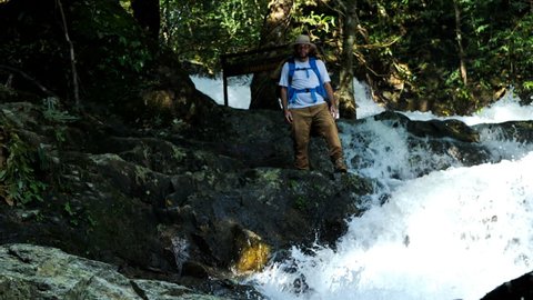 Man enjoying waterfall raised hands. Travel Lifestyle and success travel

