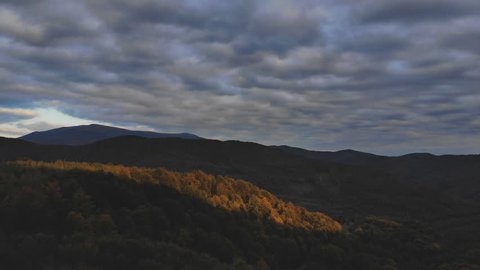 Flight over autumn mountains with forests, meadows and hills in sunset soft light. Carpathian Mountains, Ukraine, Europe. Aerial Drone Footage View: