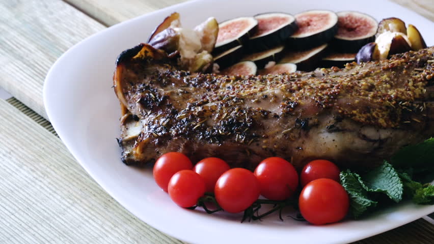 Gigot baked in oven with honey, served with fig, Feta, cherry tomatoes and greens
