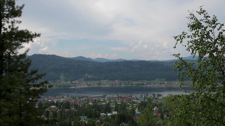 summer landscape resort recreation area in the mountains forest lake. boats floating on the lake.  evening light . Teletskoe lake, Altai mountains