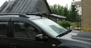 heavy rain drops on the car during the day