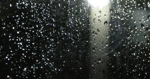 raindrops on the glass at night in front of the lamppost