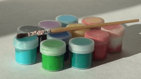 artist takes a brush from a jar of Acrylic gouache paint. Homework, the artist works. hd video