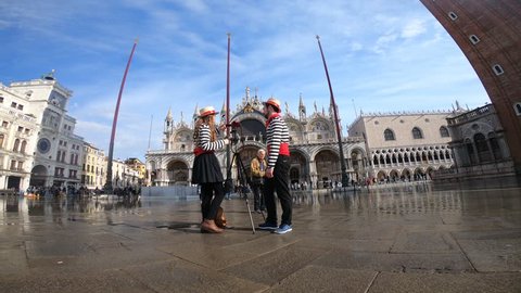 8 November 2018 - Piazza San Marco, Venice Italy - Tourists enjoy a sunny day with the high water that floods the main square of the lagoon city