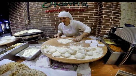 ISTANBUL, TURKEY - MAY 29, 2015: Ladies cooking gozleme in taksim Beyoglu. Gozleme is a savoury traditional Turkish dish made of hand-rolled dough that is lightly brushed with butter and eggs.
