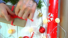 woman is wrapping Christmas presents on the table, concept of preparing for the New Year and Christmas holidays