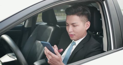 business man holding a phone and using the navigation system in the car