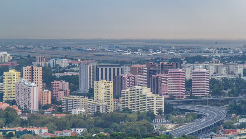 Aerial view of the airport in Lisbon, Portugal timelapse from a viewpoint in Monsanto at morning. Buildings and traffic on a road. Lisbon Portela Airport is the main international gateway to Portugal