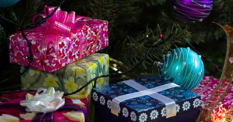 Colorful Christmas Evenings. The camera moves slowly along a variety of gift boxes decorated with glittering bows, Christmas tree decorations and sparkling garlands