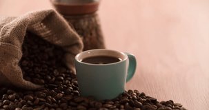 Black Coffee Cup with scattered Coffee beans and cezve coffee pot close up macro shot 4K video
