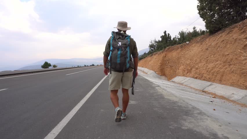 The Traveler Walk On The Road In The Mountains