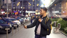 Young Attractive Man Taking Photo Selfie Using Smartphone in the evening city street. 4K Video Clip